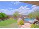 Landscaped backyard with a pool, slide, seating area and lush plantings under a cloudy sky at 26624 N 41St St, Cave Creek, AZ 85331