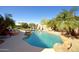 Resort-style pool with slide, lounge chairs, lush palm trees and fire pit at 26624 N 41St St, Cave Creek, AZ 85331