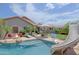 Gorgeous backyard features a sparkling pool with a water slide and lounge area, complemented by an outdoor fireplace at 26624 N 41St St, Cave Creek, AZ 85331