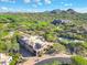 Aerial view showcasing the house and the surrounding desert landscape, golf course, and mountain views at 28990 N White Feather Ln # 185, Scottsdale, AZ 85262