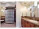 Stylish bathroom featuring a glass block shower, warm wood cabinets, and a large vanity area at 28990 N White Feather Ln # 185, Scottsdale, AZ 85262