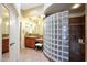 Elegant bathroom featuring a glass block shower and neutral tile flooring with a large vanity area at 28990 N White Feather Ln # 185, Scottsdale, AZ 85262