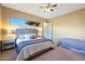 Bright bedroom with a gray bedframe, ceiling fan, carpeted floor and a window at 28990 N White Feather Ln # 185, Scottsdale, AZ 85262