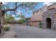 Desert home featuring a private driveway, two-car garage and decorative stone archway at 28990 N White Feather Ln # 185, Scottsdale, AZ 85262