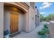 Inviting front entrance showcasing a rustic wooden door, decorative stone accents and desert landscaping at 28990 N White Feather Ln # 185, Scottsdale, AZ 85262