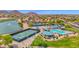Aerial view of the community showing pickleball and tennis courts, community pool, lake, mountains, and surrounding houses at 30032 N Desert Willow Blvd, San Tan Valley, AZ 85143