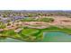 Aerial view of the lush, green golf course with sand traps and lake, surrounded by desert landscape and homes at 30032 N Desert Willow Blvd, San Tan Valley, AZ 85143