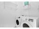 Laundry room features side-by-side washer and dryer with overhead wire shelving for storage at 30032 N Desert Willow Blvd, San Tan Valley, AZ 85143