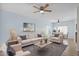 Bright living room with neutral walls, ceiling fan, and comfortable seating area featuring a gray rug at 30032 N Desert Willow Blvd, San Tan Valley, AZ 85143