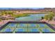 Outdoor pickleball courts surrounded by a lake and desert landscape and golf course in the background at 30032 N Desert Willow Blvd, San Tan Valley, AZ 85143