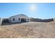 A spacious backyard featuring a rock ground cover, block wall, and the home's rear facade at 30560 W Weldon Ave, Buckeye, AZ 85396