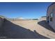 An expansive backyard featuring a gravel ground cover, a cinder block fence and views of neighborhood homes at 30560 W Weldon Ave, Buckeye, AZ 85396