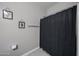 The bathroom features a black shower curtain with some leaves on the wall above the towel rack at 30560 W Weldon Ave, Buckeye, AZ 85396