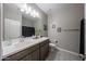 This bathroom has a toilet, sink, a shower curtain, and a vanity with framed art on the walls at 30560 W Weldon Ave, Buckeye, AZ 85396