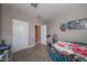 Small bedroom with a desk and chair beside bed, and two doors visible at 30560 W Weldon Ave, Buckeye, AZ 85396