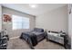 A bedroom has a bed, crib, and Tupac Shakur art, with a fan sitting on the floor at 30560 W Weldon Ave, Buckeye, AZ 85396