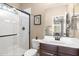 This bathroom has a large mirror over the sink, and a tiled shower with a sliding glass door at 31156 N 137Th Ln, Peoria, AZ 85383