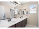 Bright bathroom featuring a double sink vanity with dark cabinets and a large mirror at 31156 N 137Th Ln, Peoria, AZ 85383