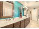 Bathroom featuring double sinks, dark wood cabinetry, and a stylish accent wall at 31156 N 137Th Ln, Peoria, AZ 85383