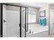 Bathroom with a separate soaking tub and shower featuring tile and a clear glass door at 31156 N 137Th Ln, Peoria, AZ 85383