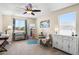 Bedroom with neutral walls, a ceiling fan, a large window, and an easel with artwork at 31156 N 137Th Ln, Peoria, AZ 85383