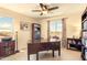 Inviting home office with built-in bookshelves, large wooden desk, bright light fixture, and lovely view of the outdoors at 31156 N 137Th Ln, Peoria, AZ 85383