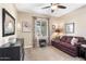 Cozy living room with a leather sofa, neutral walls, and a window overlooking the desert landscape at 31156 N 137Th Ln, Peoria, AZ 85383