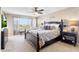 Spacious main bedroom featuring a large window with views and a dark wood bed frame at 31156 N 137Th Ln, Peoria, AZ 85383