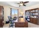 Bright home office with a large wooden desk, bookcase, and a window view of the mountains at 31156 N 137Th Ln, Peoria, AZ 85383