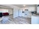 Cozy kitchen featuring white cabinetry, stainless sink and modern plank flooring, and adjoining the living area at 3209 W Charleston Ave, Phoenix, AZ 85053