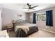 Cozy bedroom features neutral carpeting, ceiling fan, and window with dark blue curtains at 3345 E University Dr # 72, Mesa, AZ 85213