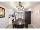 Bright dining room features modern chandelier, and kitchen with stainless steel appliances in background at 3345 E University Dr # 72, Mesa, AZ 85213