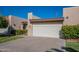 Attached two-car garage with a well-maintained desert landscape featuring mature shrubs and green grass at 3345 E University Dr # 72, Mesa, AZ 85213