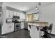 Well-lit kitchen with stainless steel appliances, granite countertops, and a breakfast bar at 3711 S Judd St, Tempe, AZ 85282