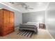 Cozy bedroom with a ceiling fan, wooden wardrobe, carpeted floors, and a gray accent wall at 3784 E Simpson Ct, Gilbert, AZ 85297