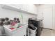 Functional laundry room includes a utility sink, modern washer and dryer, and white cabinets for storage at 3784 E Simpson Ct, Gilbert, AZ 85297