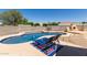 Beautiful backyard pool featuring an attached spa, poolside lounge chairs, and a custom built outdoor fireplace at 3784 E Simpson Ct, Gilbert, AZ 85297