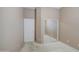 A simple bedroom with neutral walls, carpet, and closet with mirrored doors at 43302 W Bunker Dr, Maricopa, AZ 85138