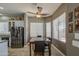 Cozy dining area with a granite-topped table, ceiling fan, and natural light from the large windows at 43302 W Bunker Dr, Maricopa, AZ 85138