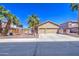 Well-maintained single-story home with a three car garage, palm trees, and desert landscaping at 43302 W Bunker Dr, Maricopa, AZ 85138