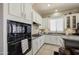 Kitchen with white cabinets, tiled floors, black appliances, and a breakfast bar at 43302 W Bunker Dr, Maricopa, AZ 85138