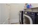 Functional laundry room with side-by-side washer and dryer, ample shelving, and closet space at 43302 W Bunker Dr, Maricopa, AZ 85138