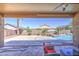 Covered patio overlooking the serene pool area, ideal for outdoor dining and relaxation at 43302 W Bunker Dr, Maricopa, AZ 85138