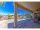Inviting pool area with palm trees, desert landscaping, and a covered patio for outdoor relaxation at 43302 W Bunker Dr, Maricopa, AZ 85138