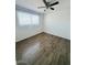 Bright bedroom with wood-look flooring, a ceiling fan, and a large window for ample natural light at 4517 S Grandview Ave, Tempe, AZ 85282
