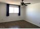 Bedroom featuring a large window with black curtains, ceiling fan, and neutral walls at 4517 S Grandview Ave, Tempe, AZ 85282
