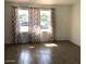 Bright living room featuring wood-look tile flooring and large windows with decorative curtains at 4517 S Grandview Ave, Tempe, AZ 85282