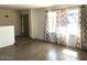 Bright living room featuring wood-look tile flooring and large windows with decorative curtains at 4517 S Grandview Ave, Tempe, AZ 85282