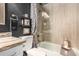 Stylish bathroom features a shower-tub combo, neutral tiling, dark walls, and modern fixtures at 5018 E Kathleen Rd, Scottsdale, AZ 85254