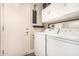 Neat laundry room featuring white cabinets and appliances, with direct access to the outdoors at 5018 E Kathleen Rd, Scottsdale, AZ 85254